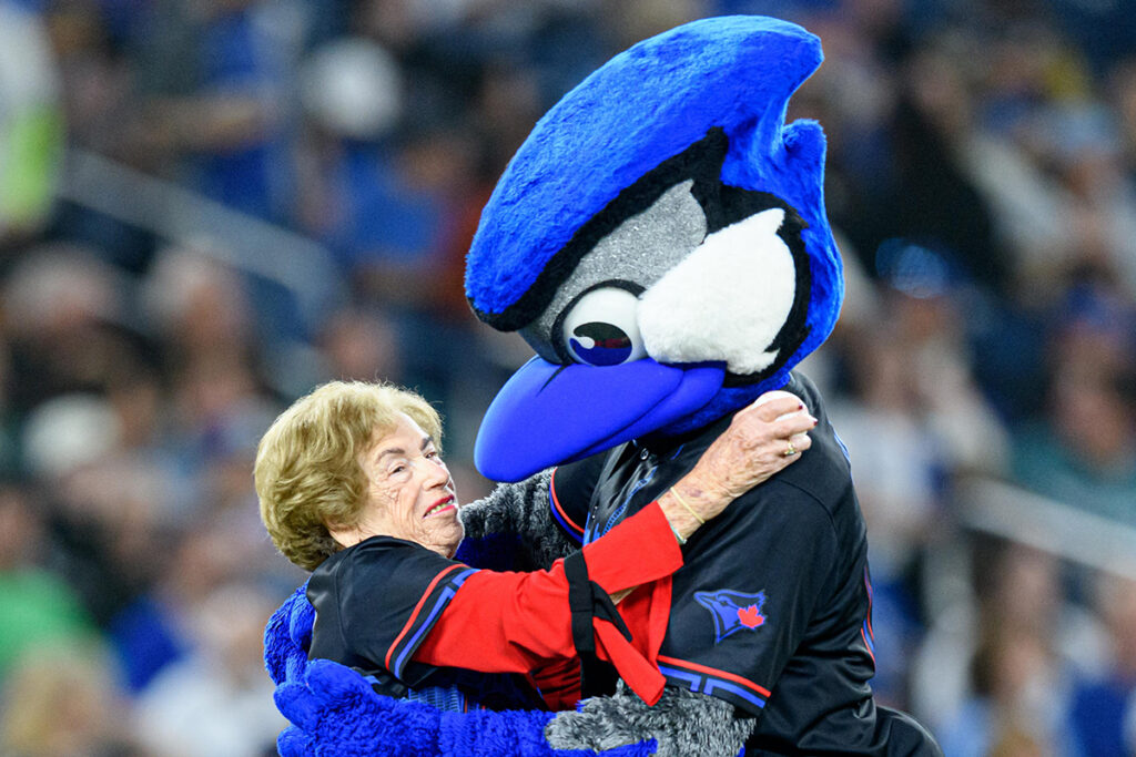 TORONTO, ON - SEPTEMBER 09: Holocaust survivor Irene Kurtz hugs the Blue Jays mascot after throwing the ceremonial first pitch before the MLB baseball regular season game between the New York Mets and the Toronto Blue Jays on September 9, 2024, at Rogers Centre in Toronto, ON, Canada.