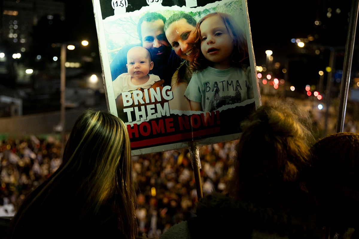 TEL AVIV, ISRAEL - DECEMBER 28: A protester holds a sign with photos of the Bibas family who is held hostage in the Gaza Strip during a rally calling for an hostages deal with Hamas on December 28, 2024 in Tel Aviv, Israel.