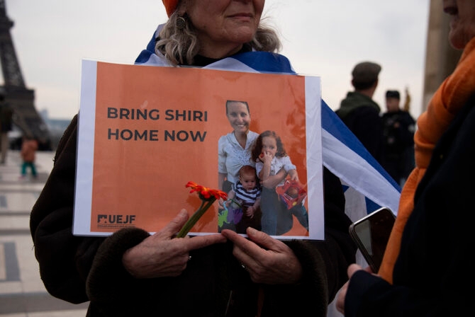 A woman holds a poster showing Ariel, Kfir and Shiri Bibas and asking to bring back Shiri during a gathering in tribute to Israeli hostages, Oded Lifshitz and to the Bibas family at the Trocadero square in Paris on February 21, 2025.